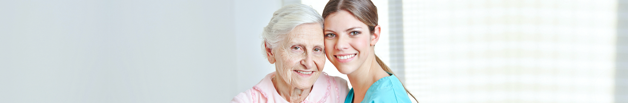 senior woman and caregiver smiling