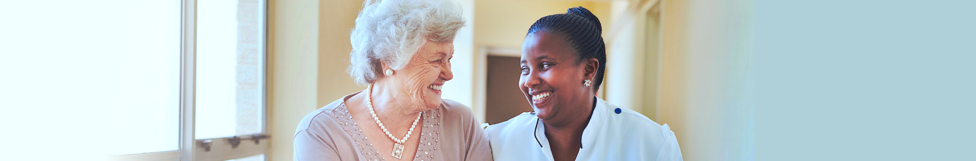 senior woman and caregiver smiling at each other